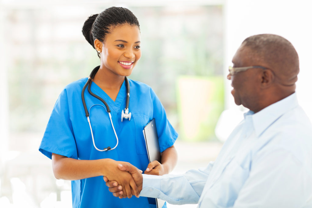 Friendly doctor shaking hands with senior patient
